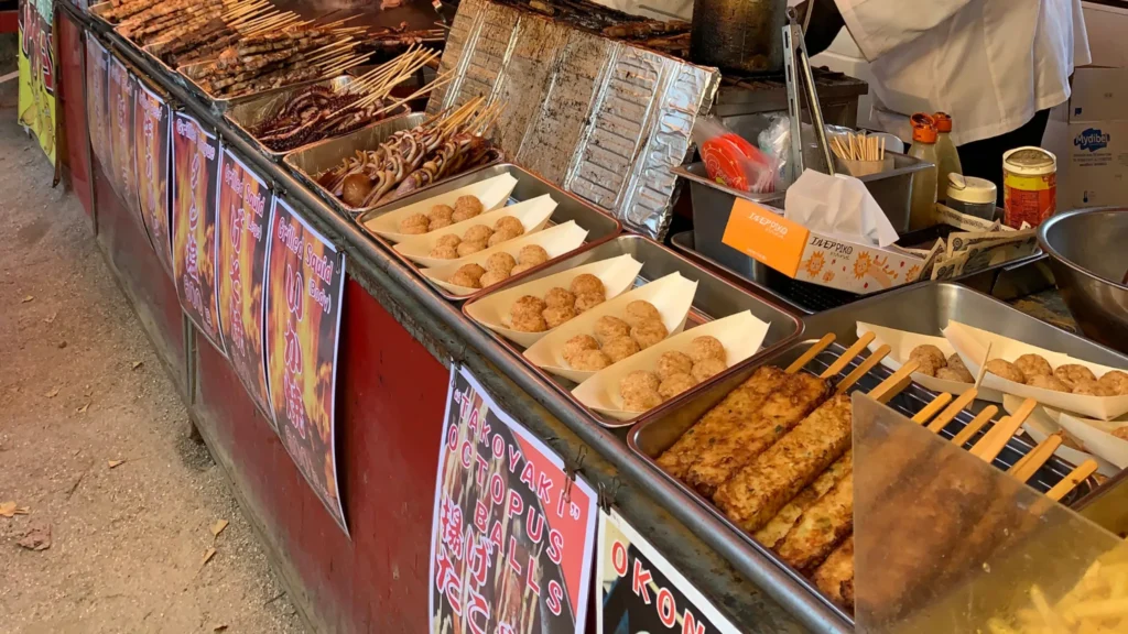 Comida típica japonesa en puestos callejeros con takoyaki y calamares a la parrilla
