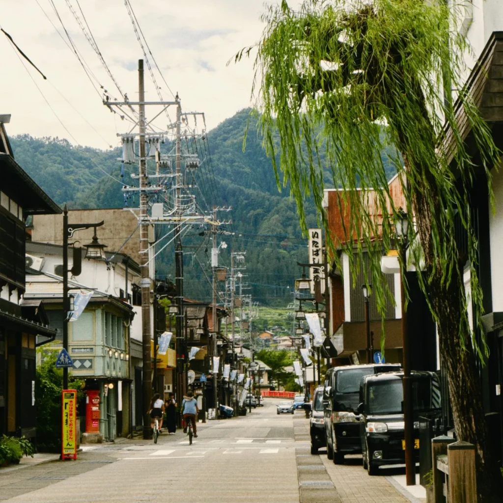 Calles antiguas de Hida Furukawa con ciclistas y montañas al fondo