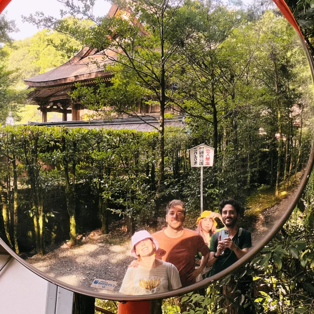 Grupo de amigos reflejados en un espejo en un templo japonés
