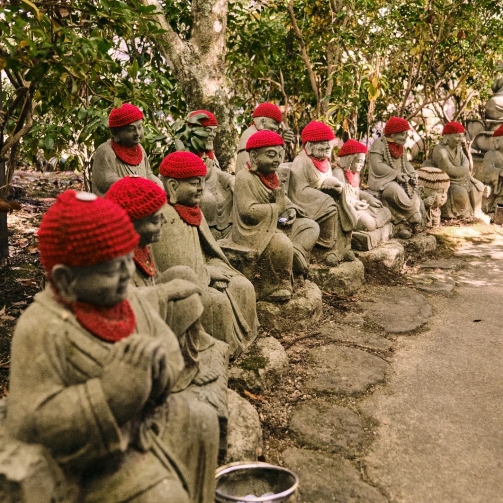 Estatuillas jizo con gorritos y pañuelos rojos en el templo Daishoin.