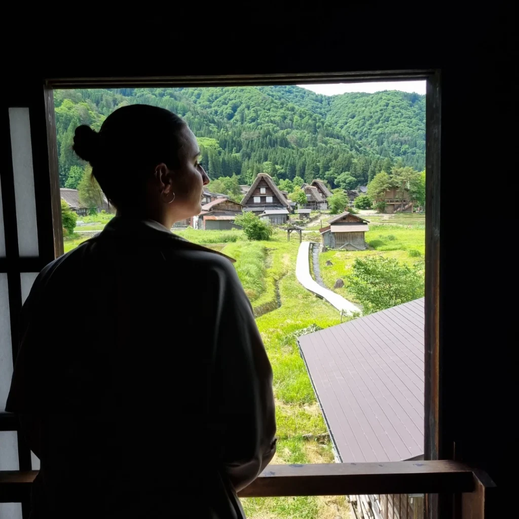 Persona observando desde el interior de las casas gassho-zukuri en una ventana elevada.
