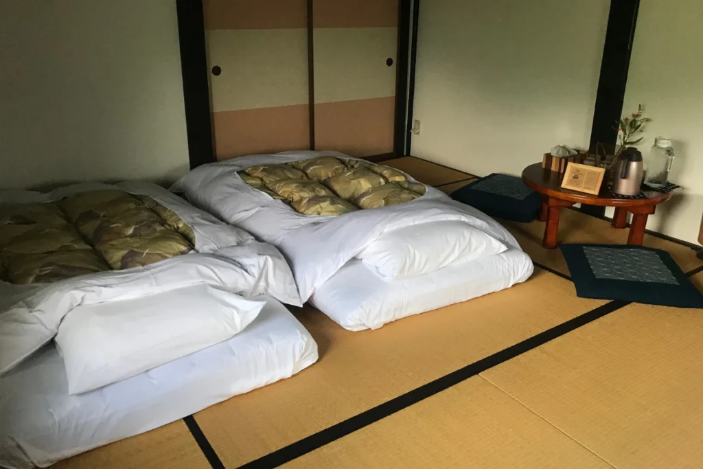 Habitación de ryokan japonés con futones sobre tatami.