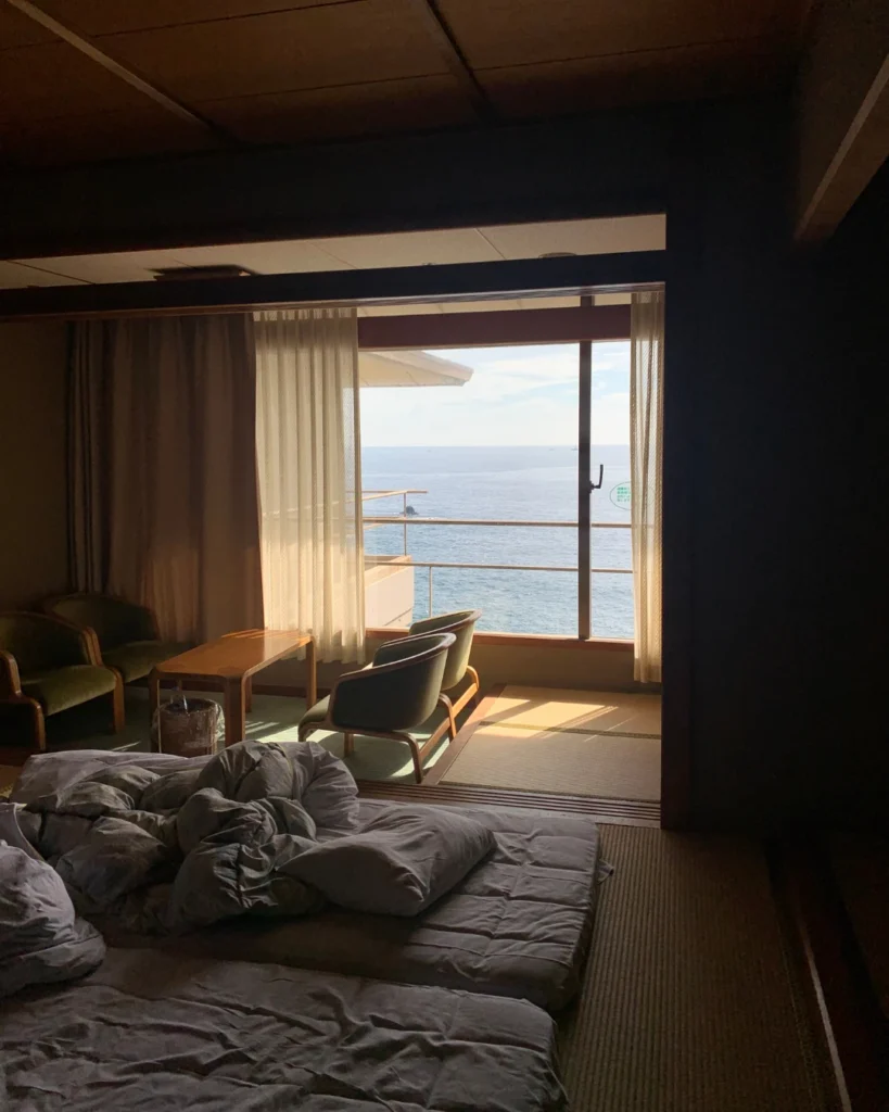 Ryokan japonés con futones y vistas al océano.
