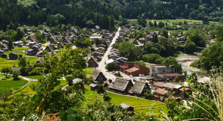 Vista elevada de Shirakawago con casas gassho-zukuri distribuidas por el valle y montañas alrededor.