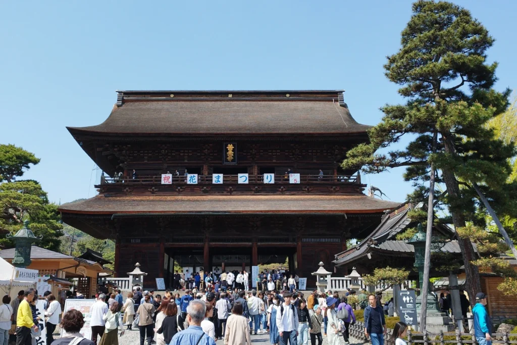 Templo Zenkoji en Nagano con peregrinos y visitantes entrando por la puerta principal