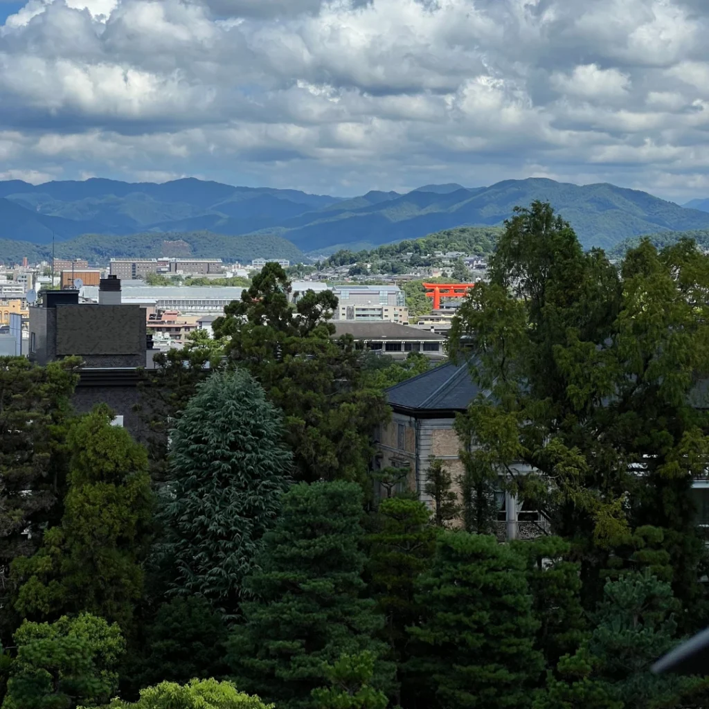 Vista de Kioto con montañas al fondo y un gran torii rojo, ideal para inspirar itinerarios japon con naturaleza y ciudad.