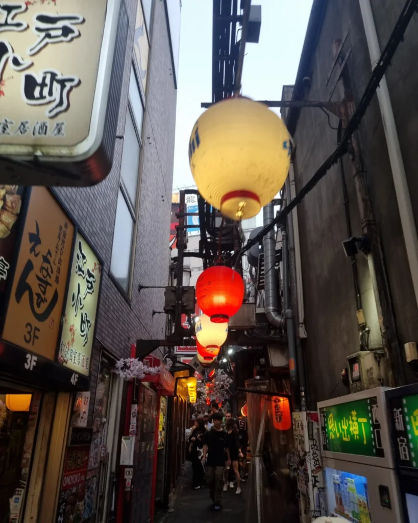 calle estrecha de izakayas en Shinjuku Tokio iluminada con farolillos