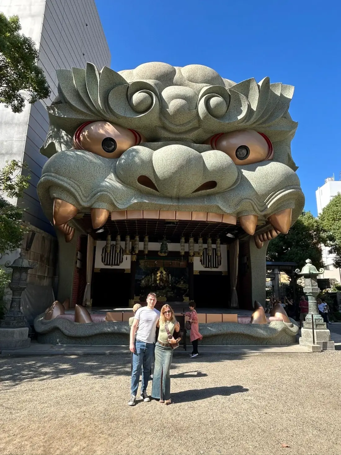 Viajeros en Santuario Namba Yasaka en Osaka japoneo 2 Pareja frente a la cabeza de león del santuario Namba Yasaka en Osaka