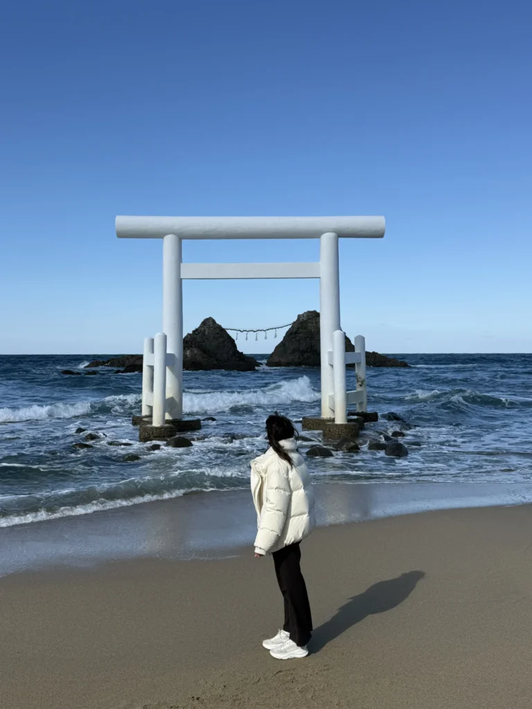 Torii blanco frente al mar en un santuario sintoísta, religión de Japón