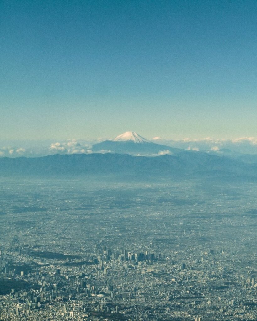 Espectacular vista aérea del Monte Fuji nevado sobre la ciudad desde un avión.